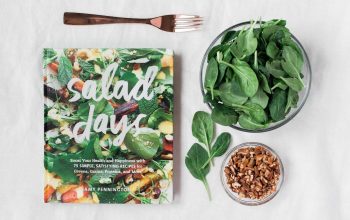 Salad day cookbook beside clear glass bowl with vegetable